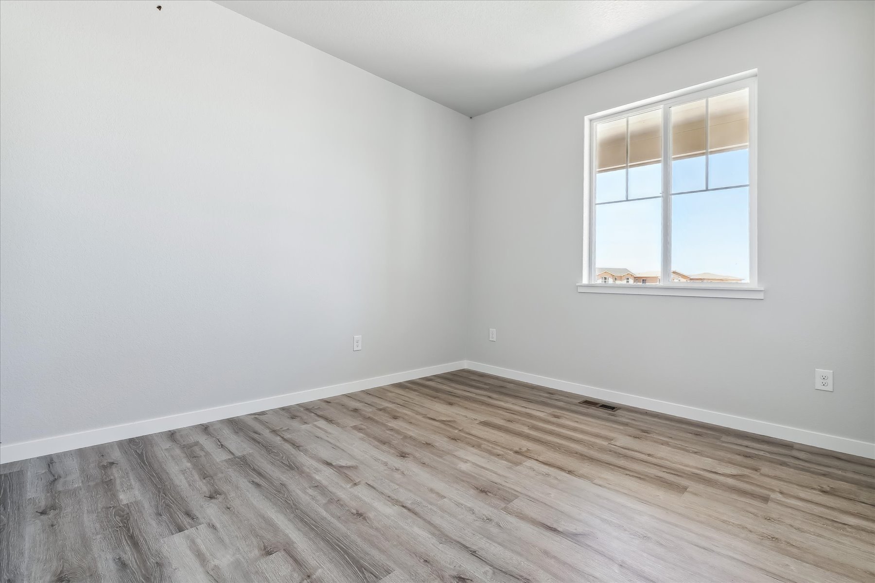 A room with a wood floor and a window.