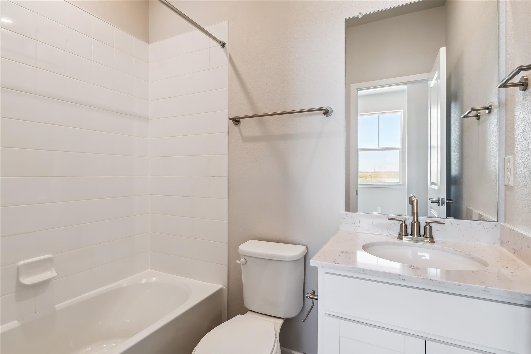 A bathroom with a tub sink and toilet.