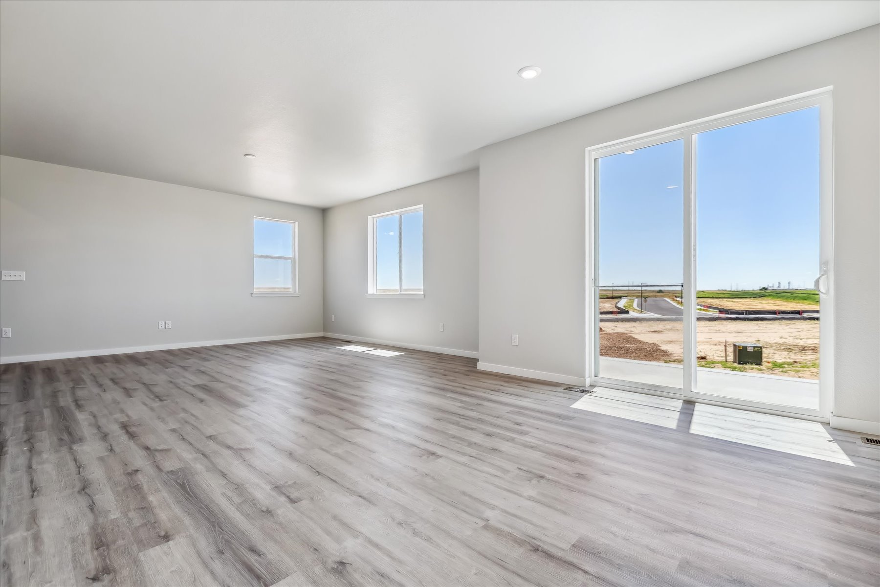 A room with a wood floor and windows.