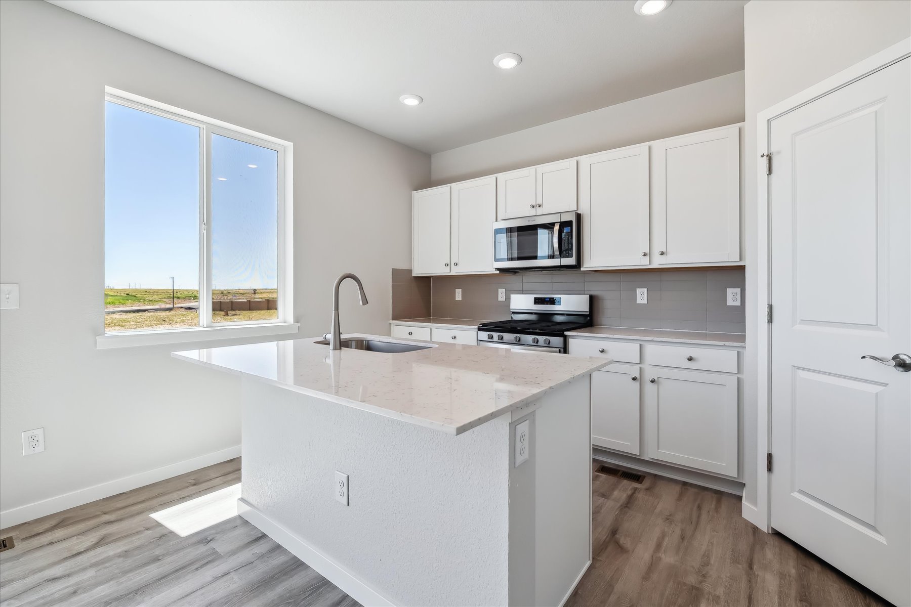A kitchen with white cabinets.