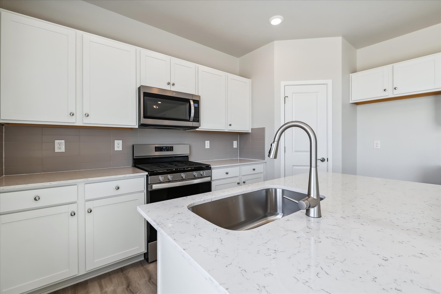 A kitchen with white cabinets.