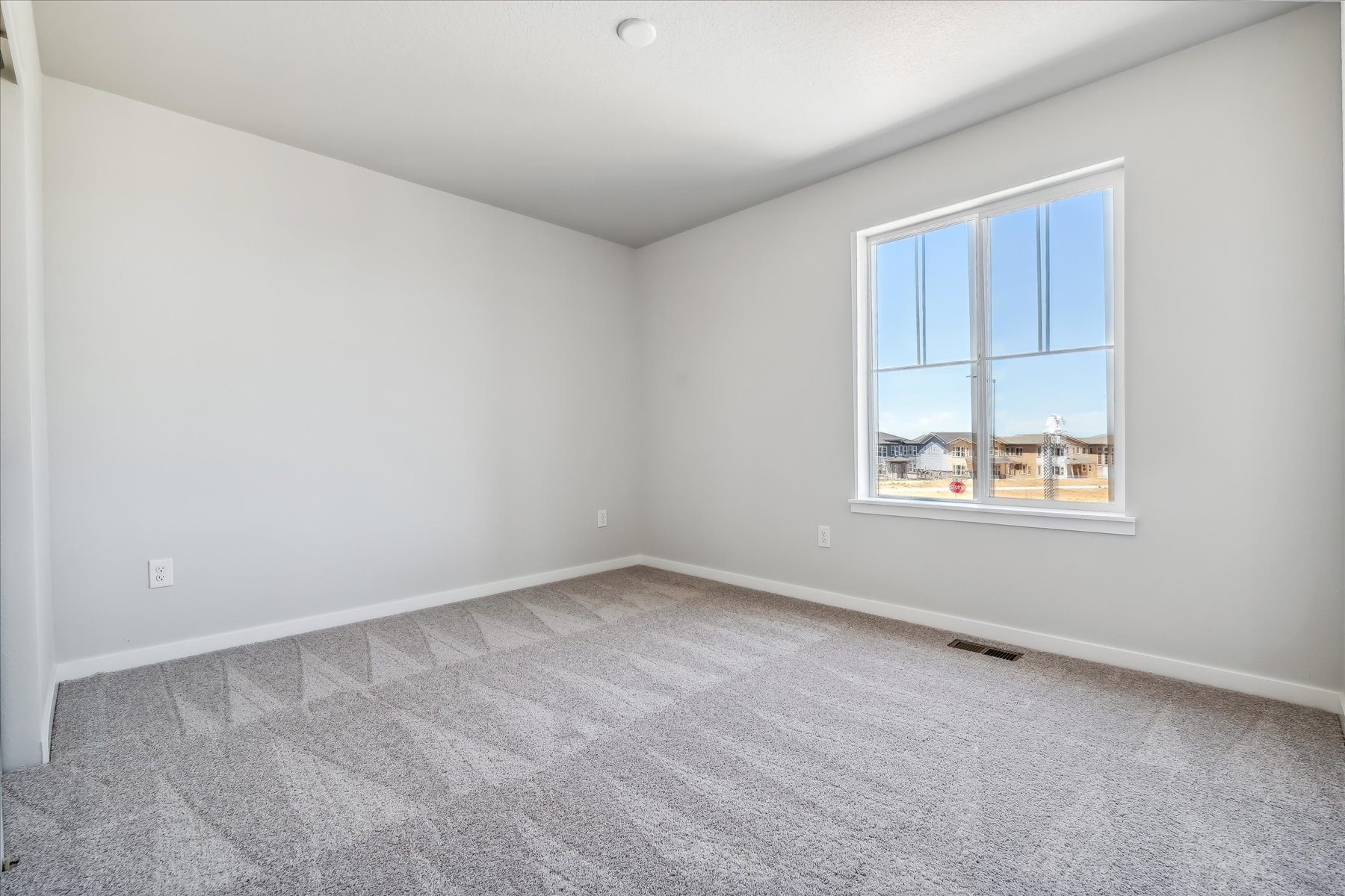 A room with a window and a carpet.