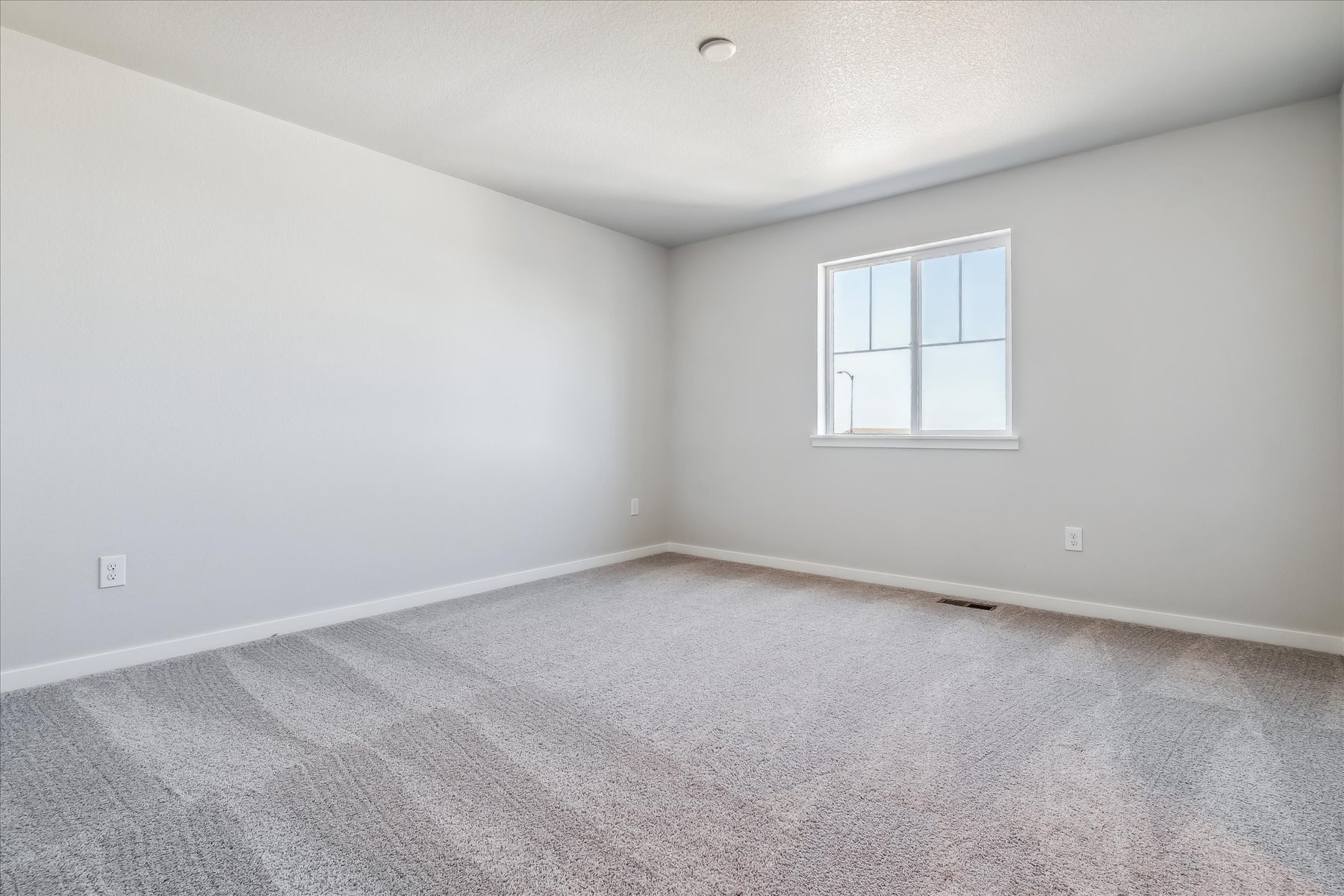 A room with a window and carpet.
