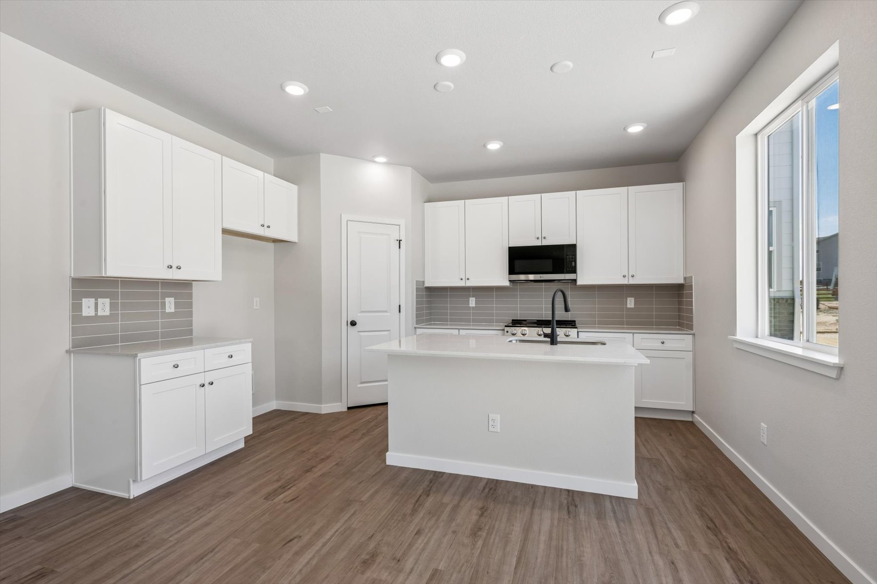 A kitchen with white cabinets.