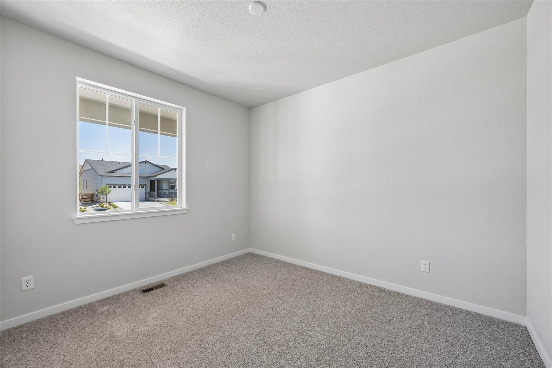A room with a window and a carpet.
