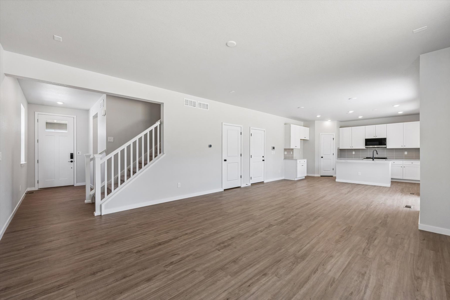 A room with white walls and wood floors.