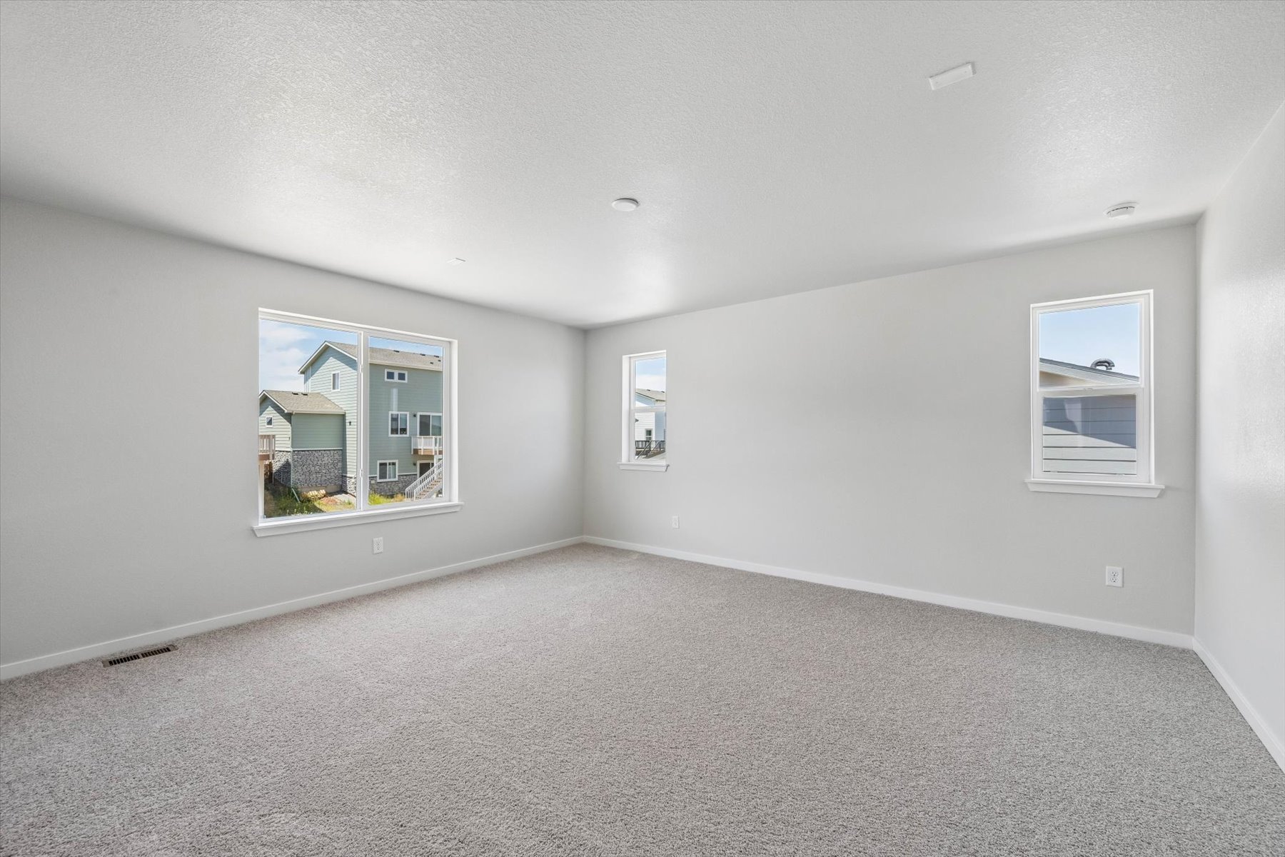 A room with a carpet and windows.