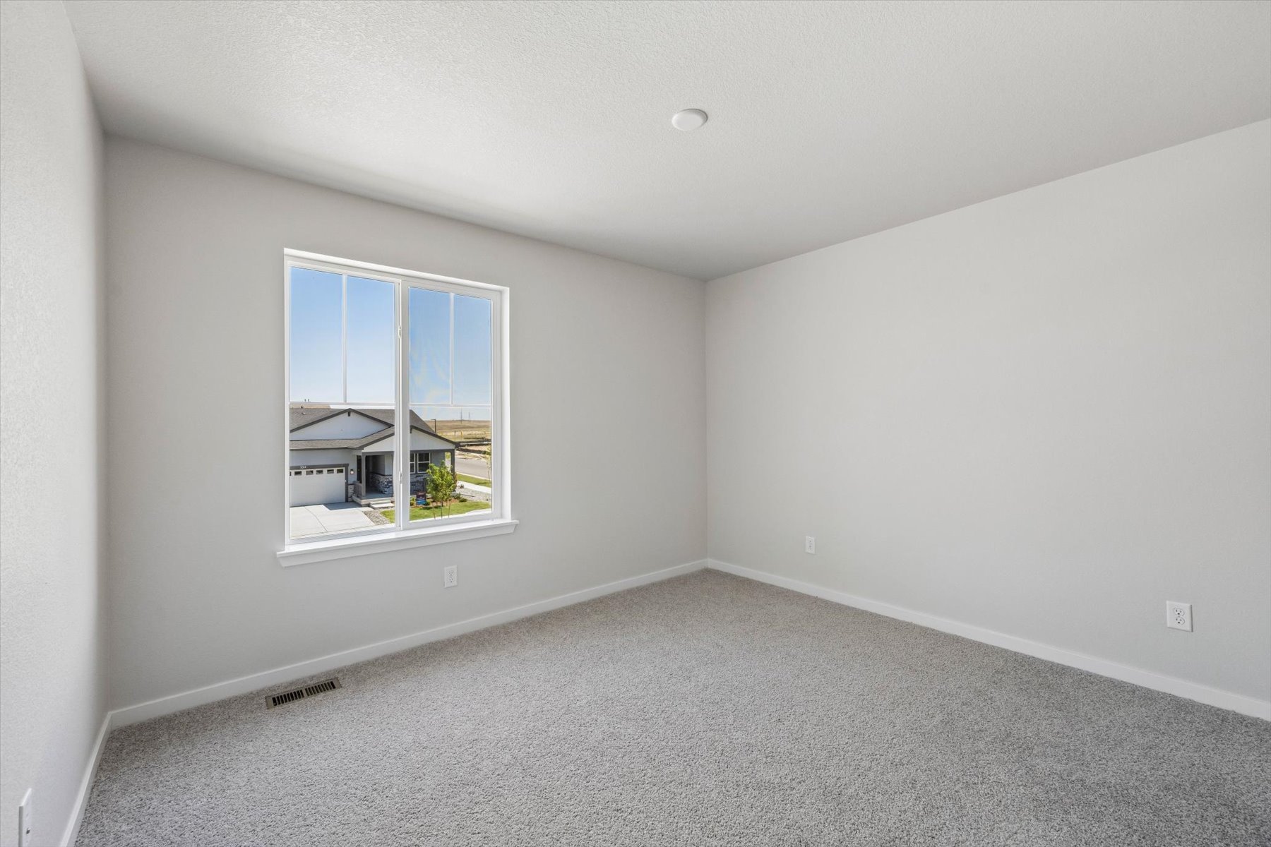 A room with a window and a carpet.