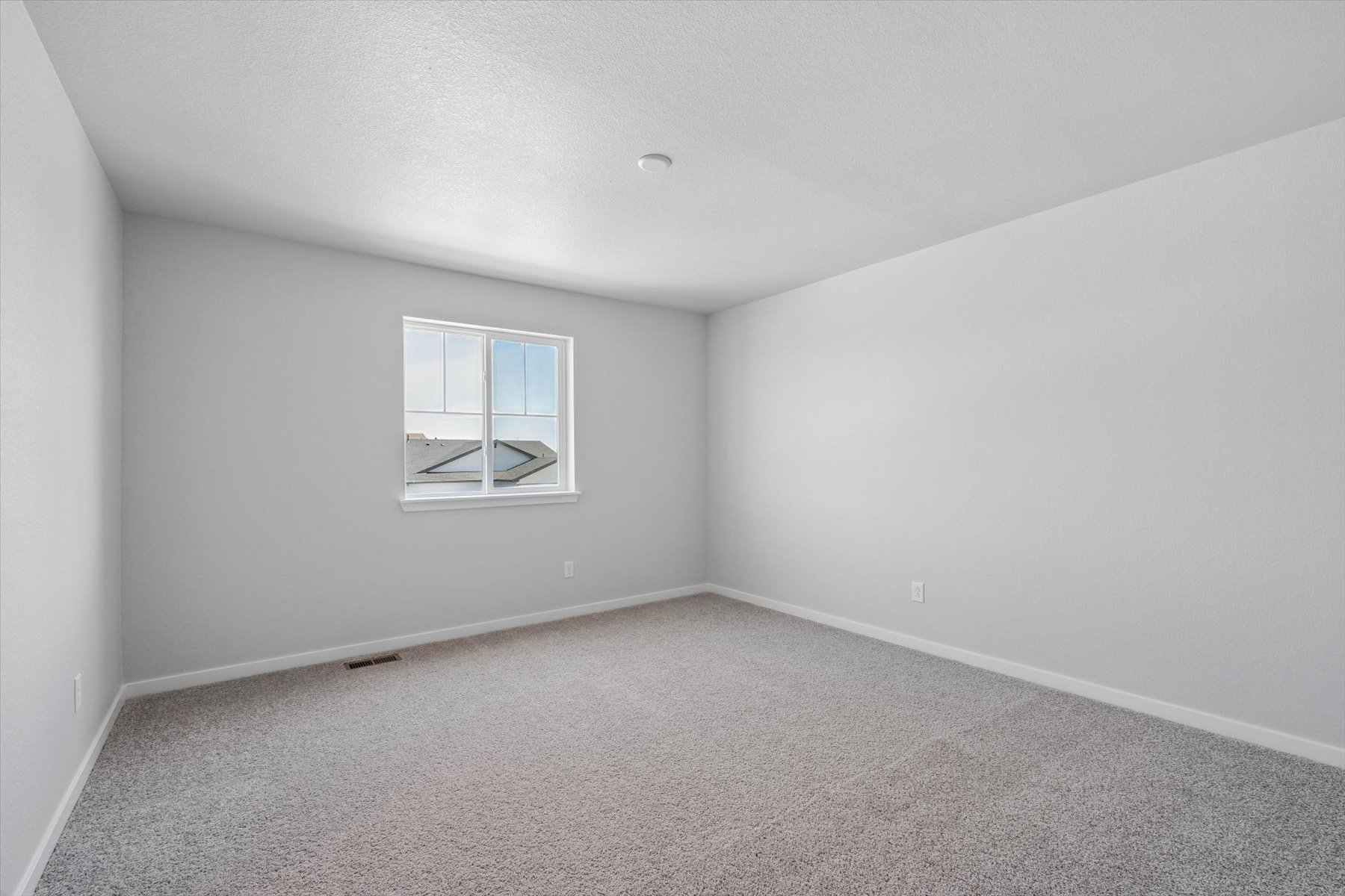 A room with a window and carpet.