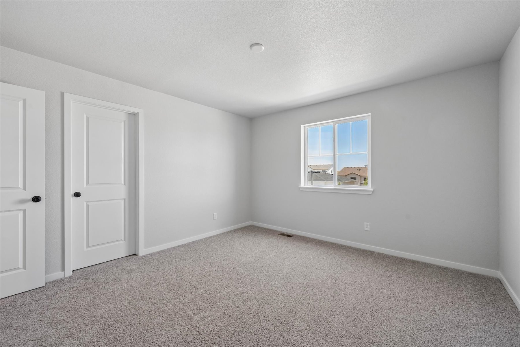 A room with white doors and a window.