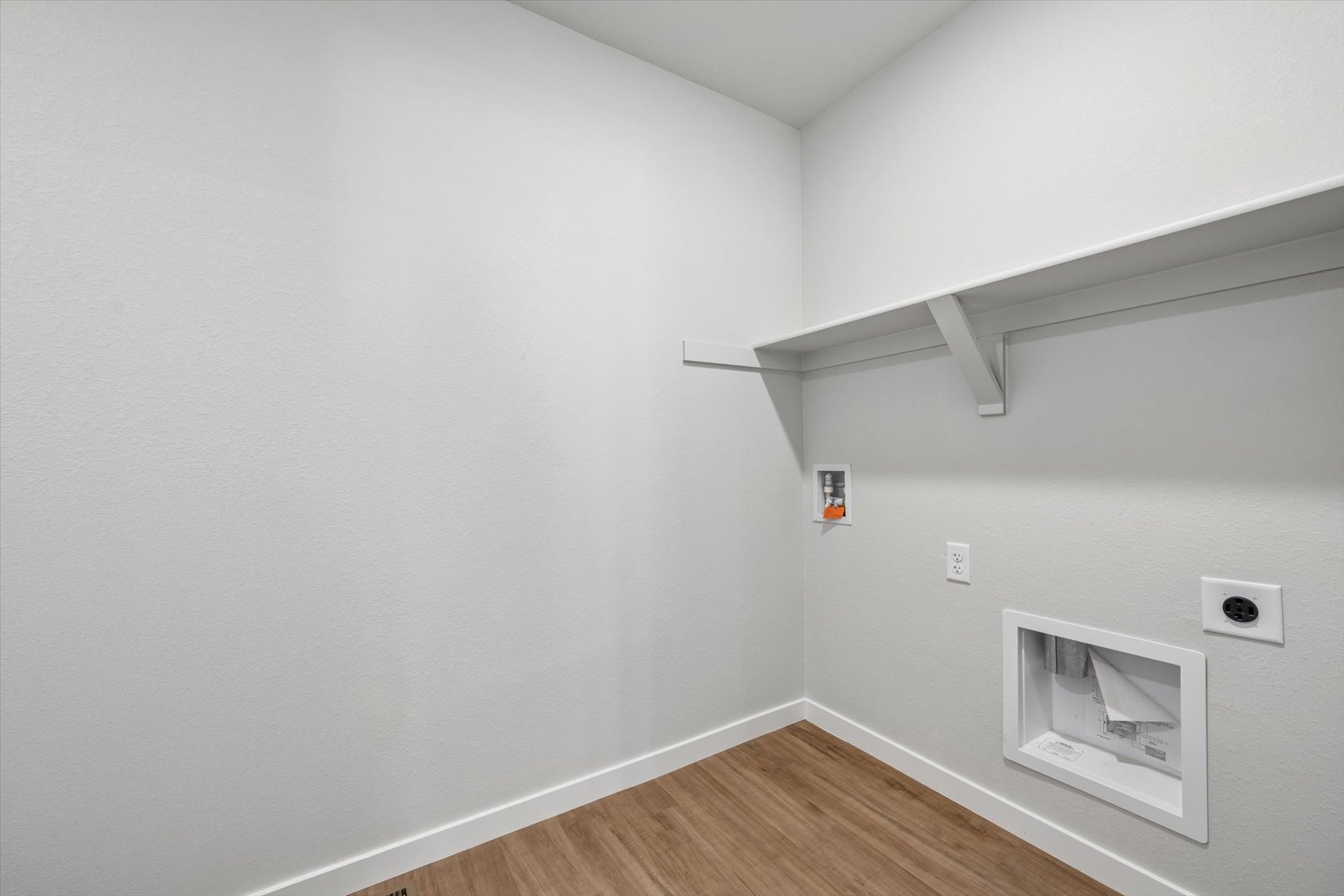 A white room with a wood floor.
