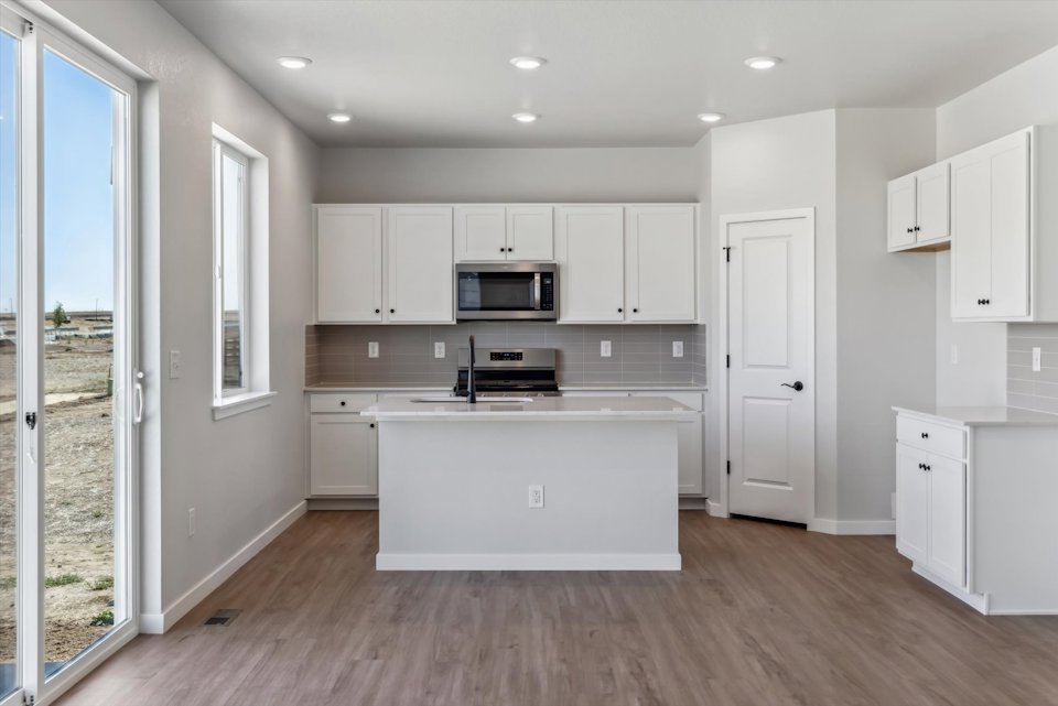 A kitchen with white cabinets.