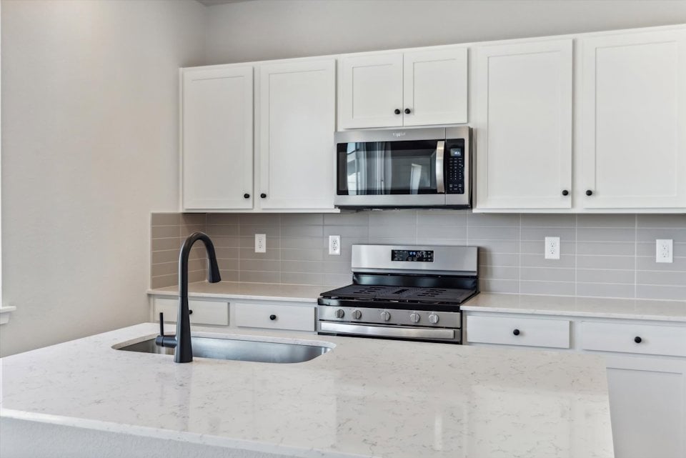 A kitchen with white cabinets.