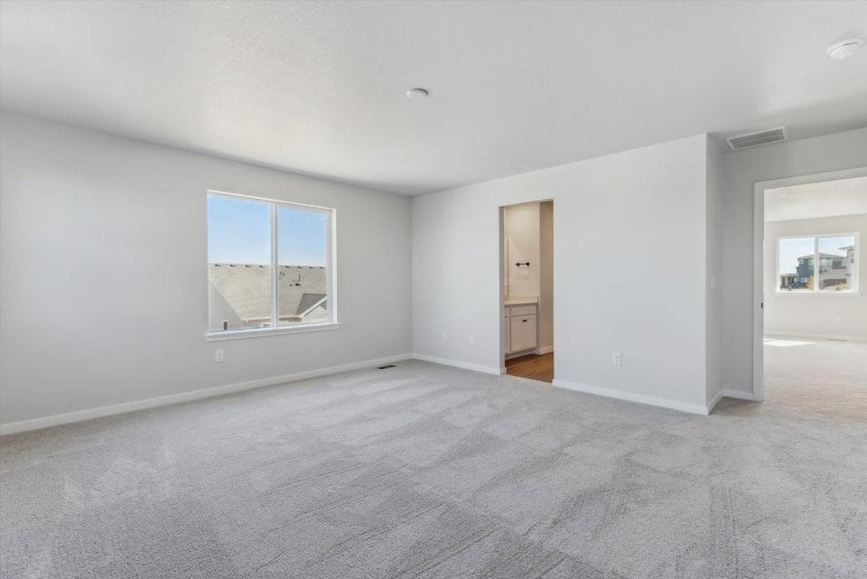 A room with a white carpet and a window.