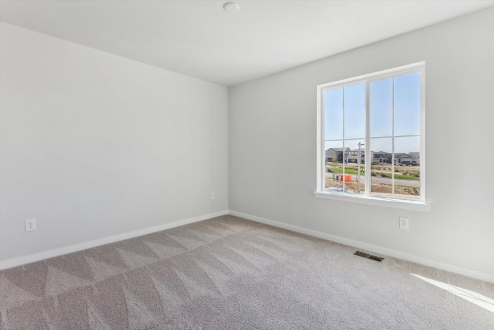 A room with a window and a carpet.