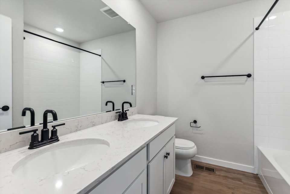 A bathroom with a tub sink and toilet.