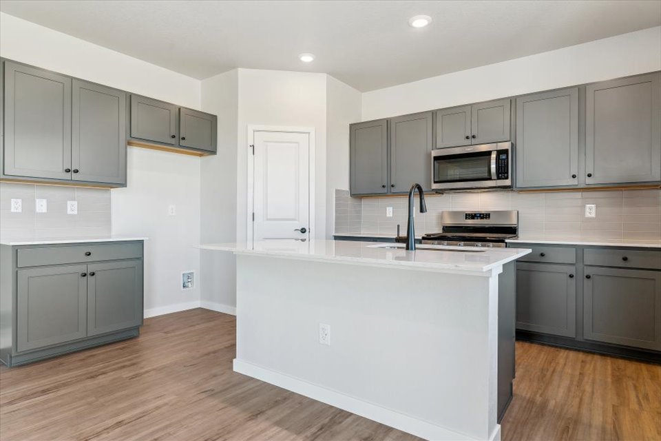 A kitchen with white cabinets.