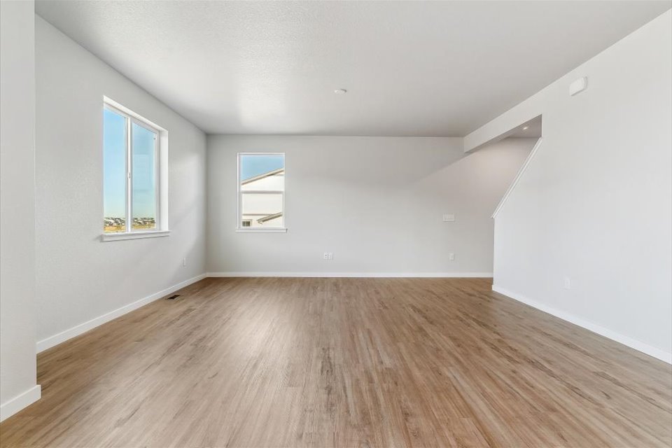 A room with a wood floor and windows.