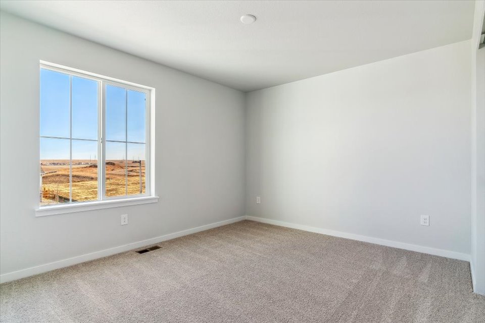 A room with a window and a carpet.