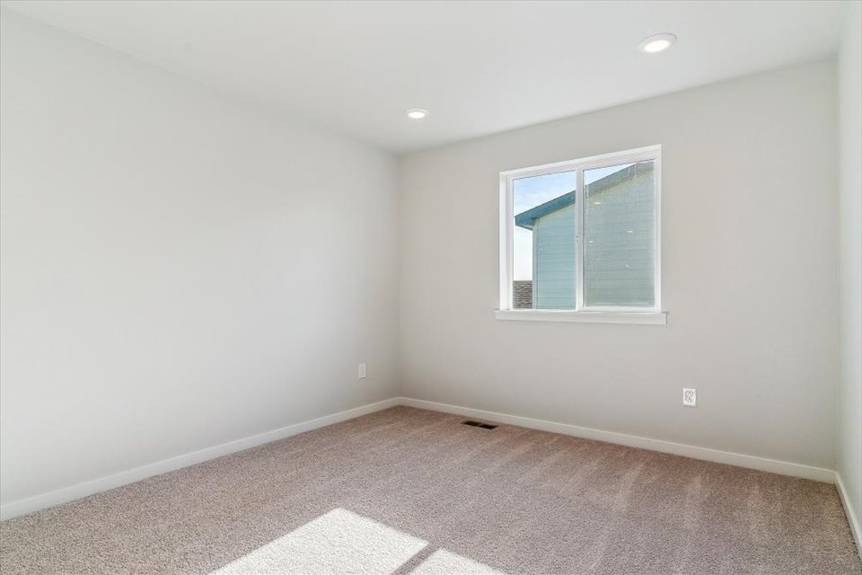 A room with a window and a rug.