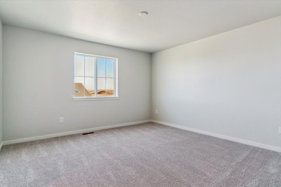A room with a window and carpet.