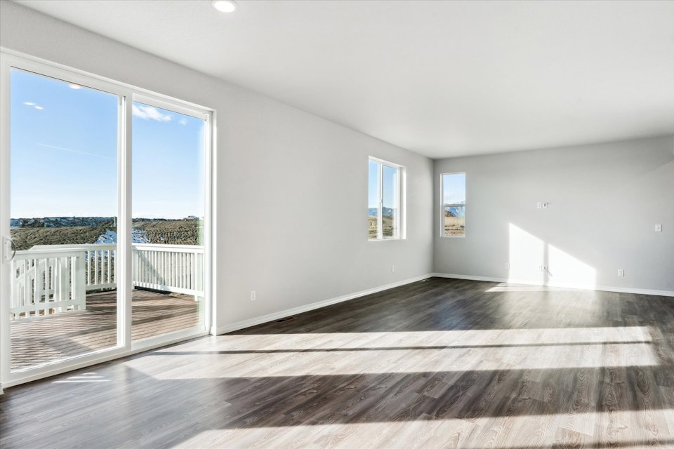 A room with a wood floor and a large window.