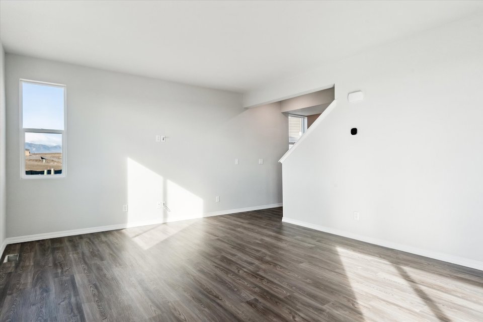 A room with a wood floor and windows.