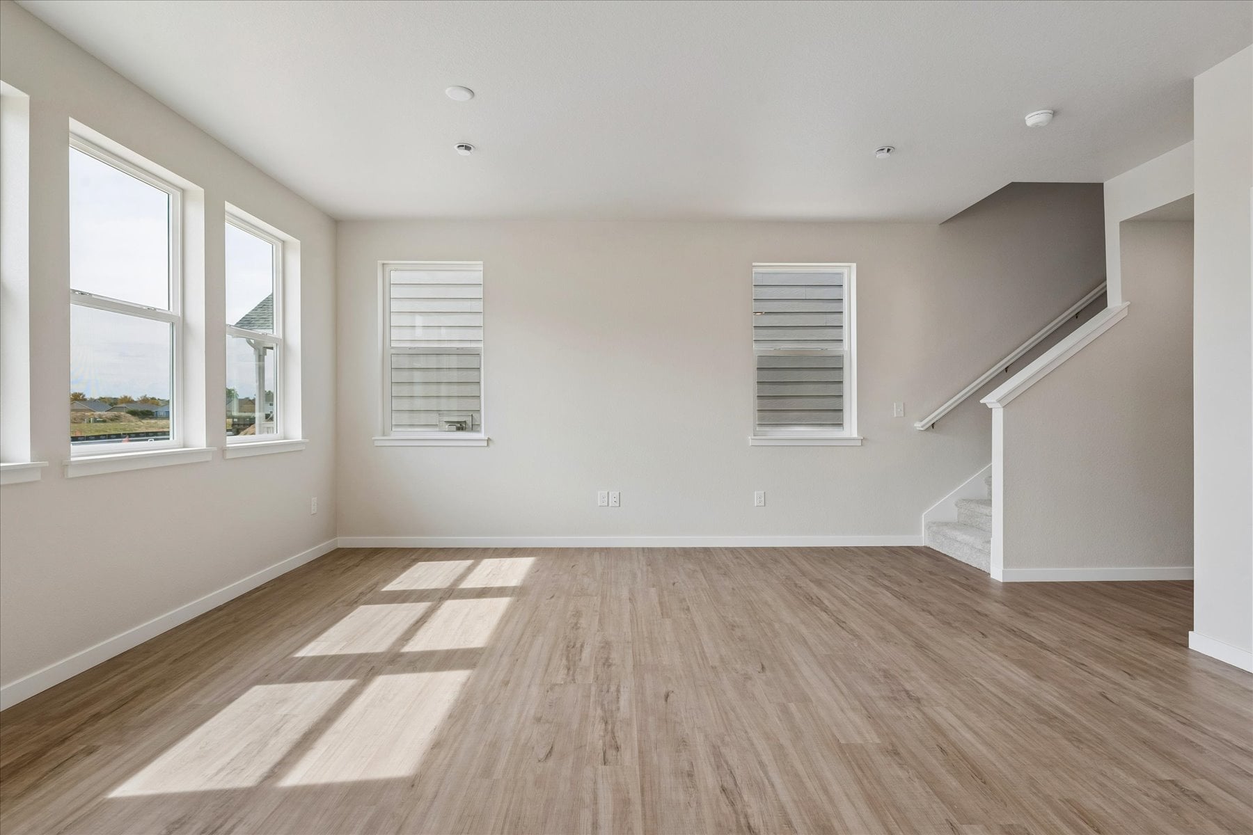 A room with a wood floor and windows.