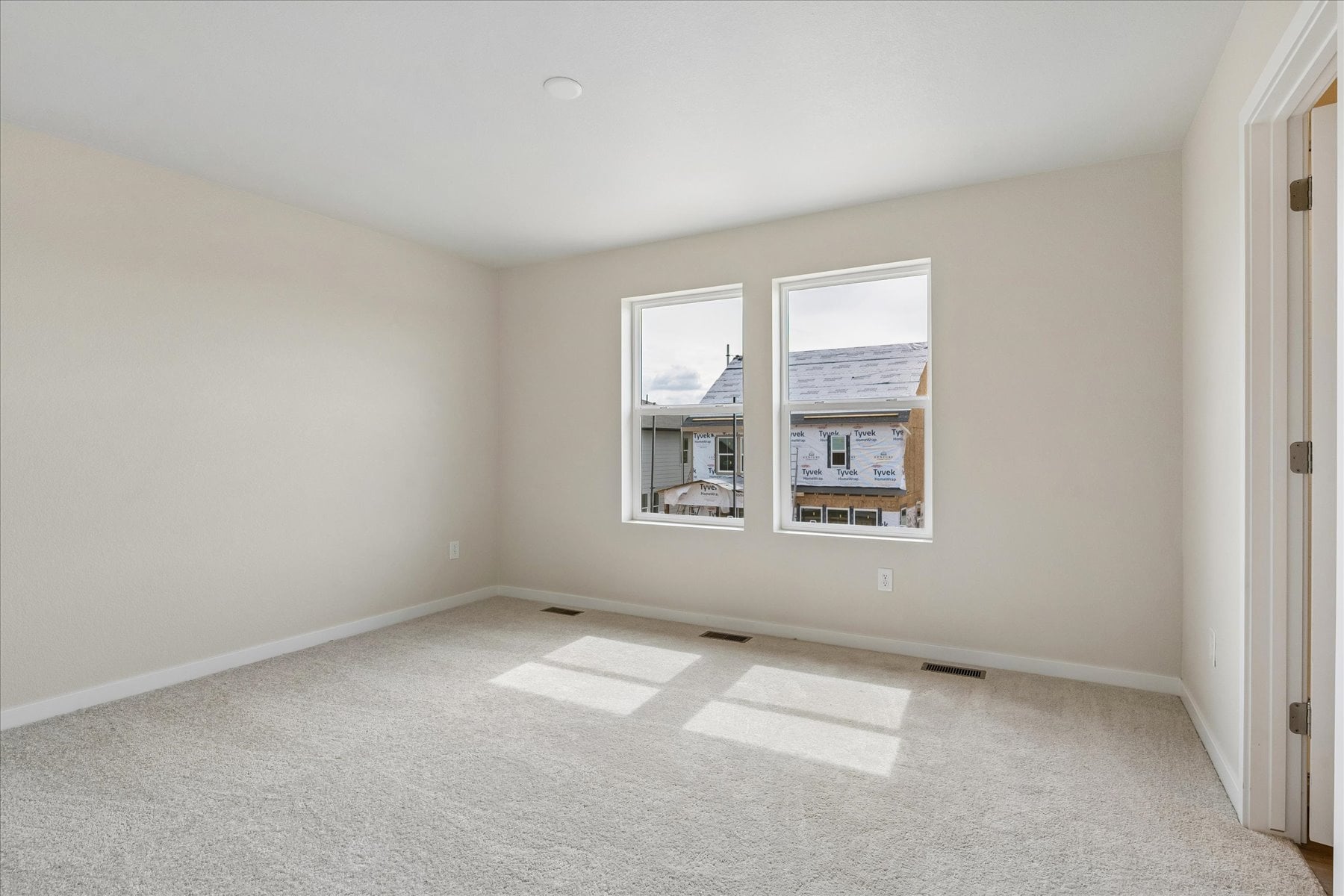 A room with a window and a rug.