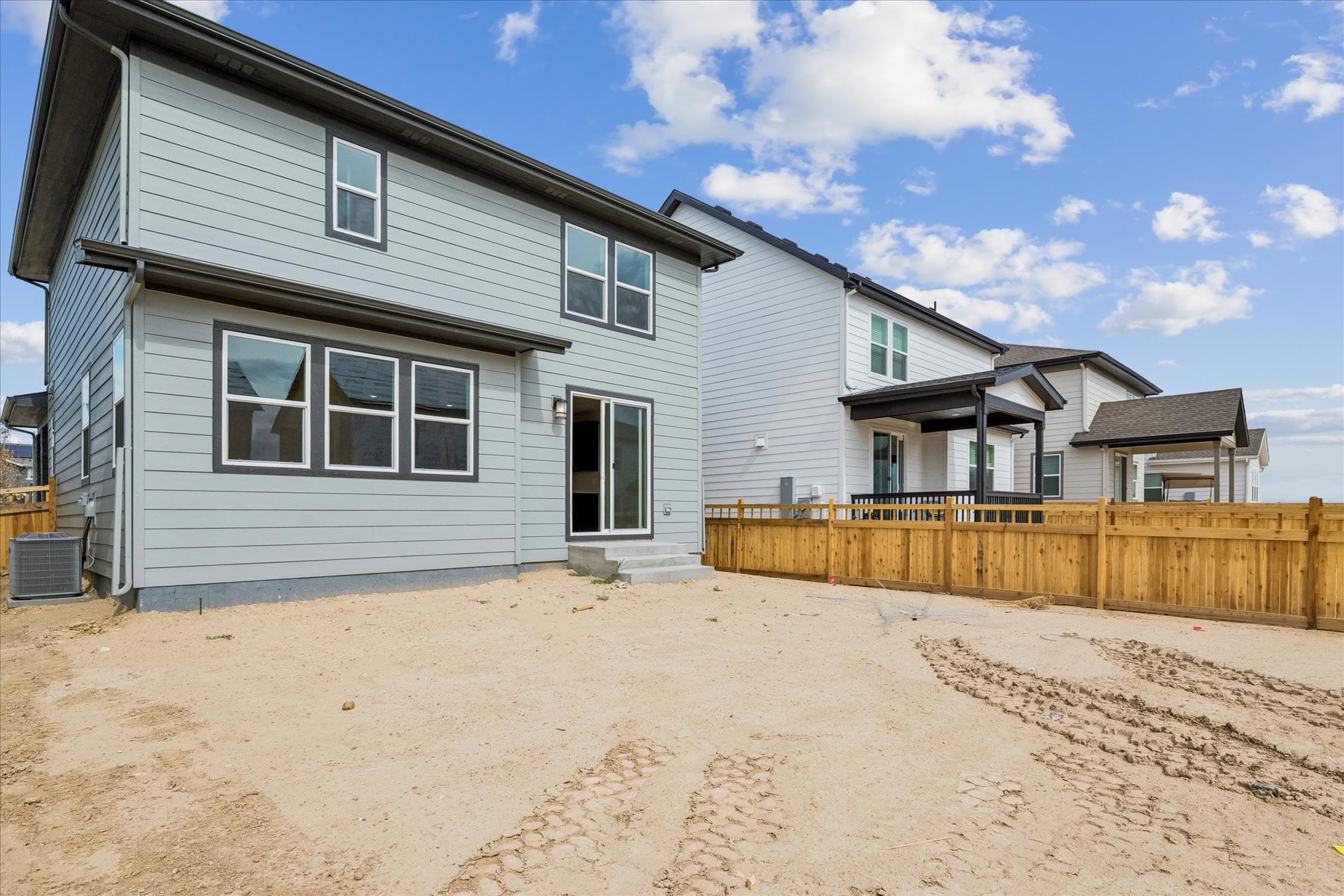 A house with a fence and sand.