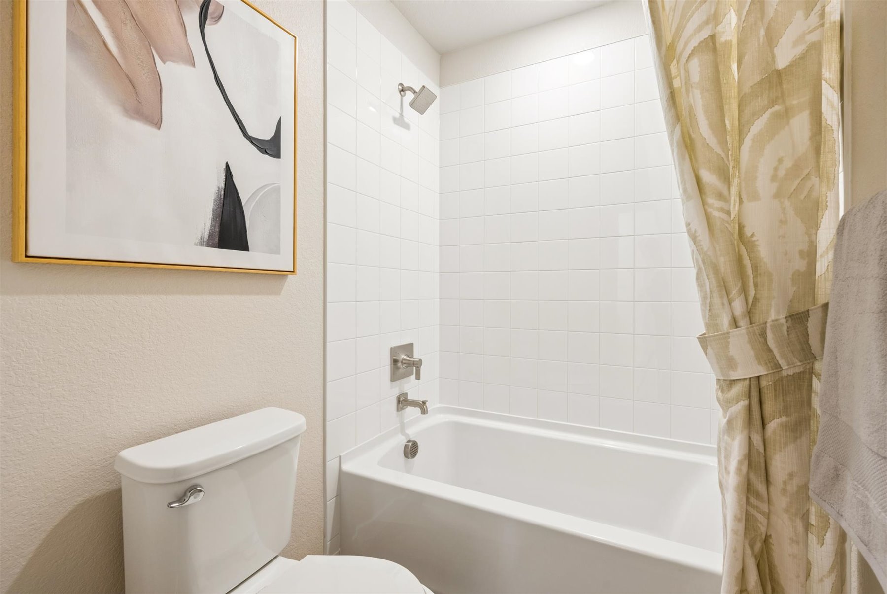 A bathroom with a tub toilet and a mirror.