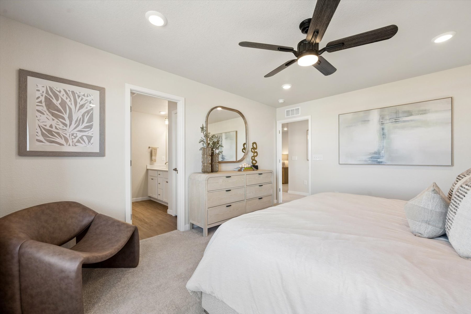 A bedroom with a bed and a chair.
