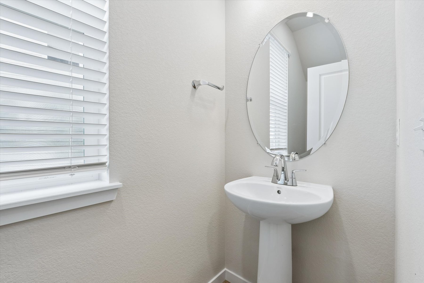 A bathroom with a round mirror.