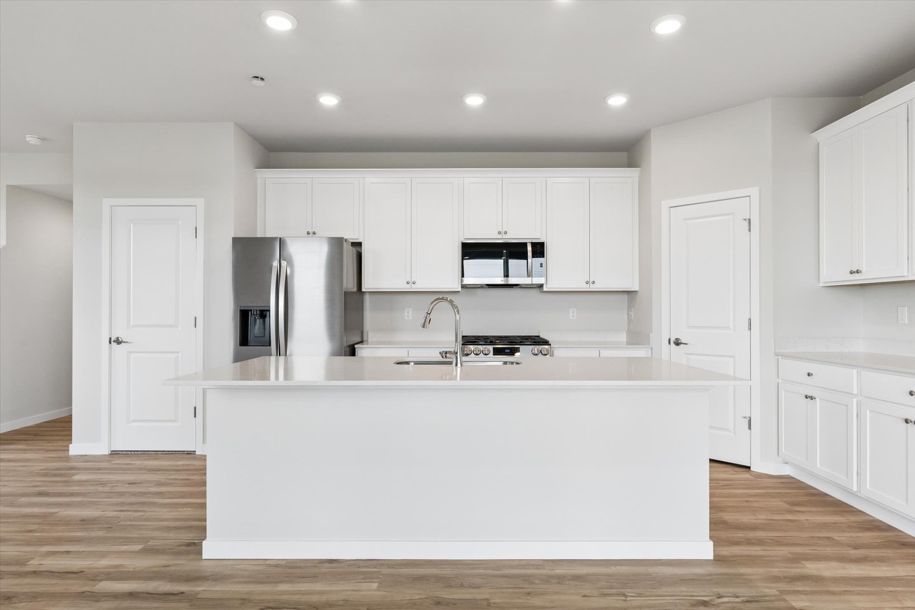 A kitchen with white cabinets.