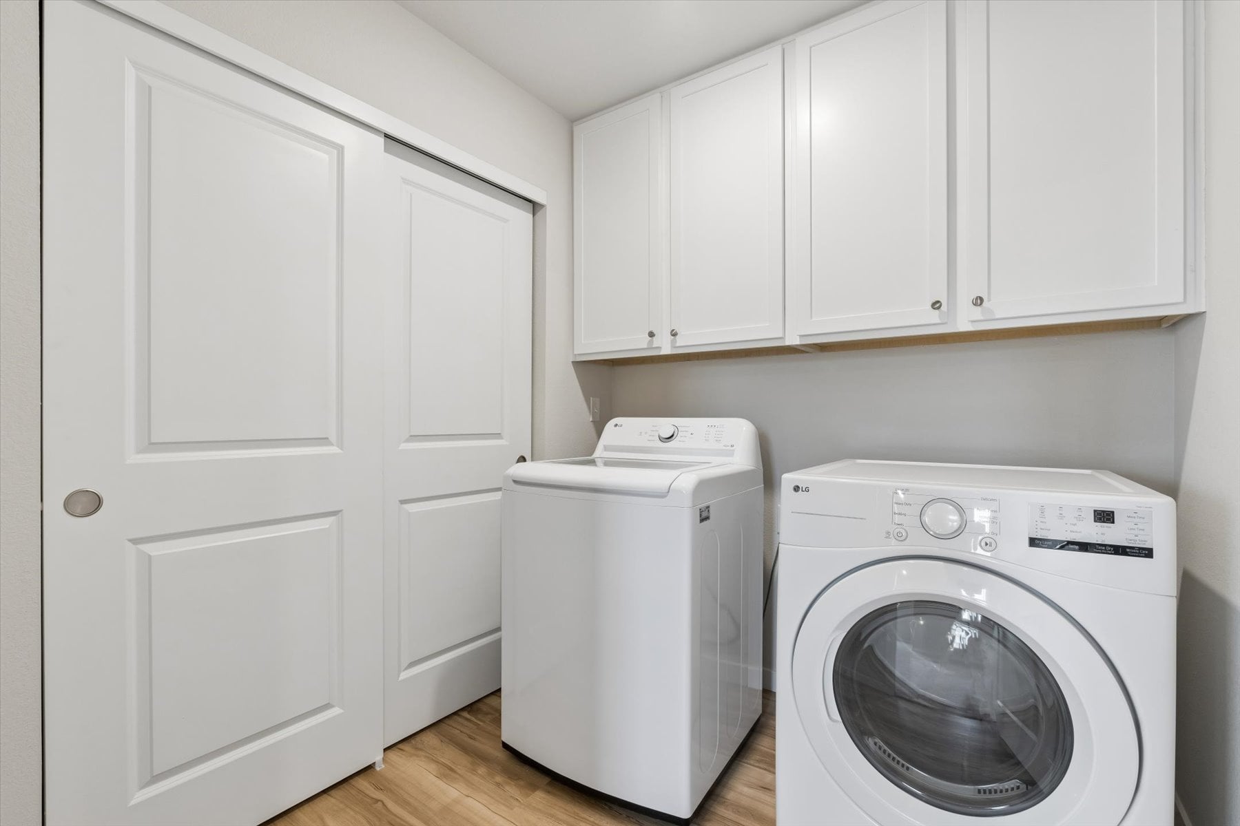 A white laundry machine in a room.