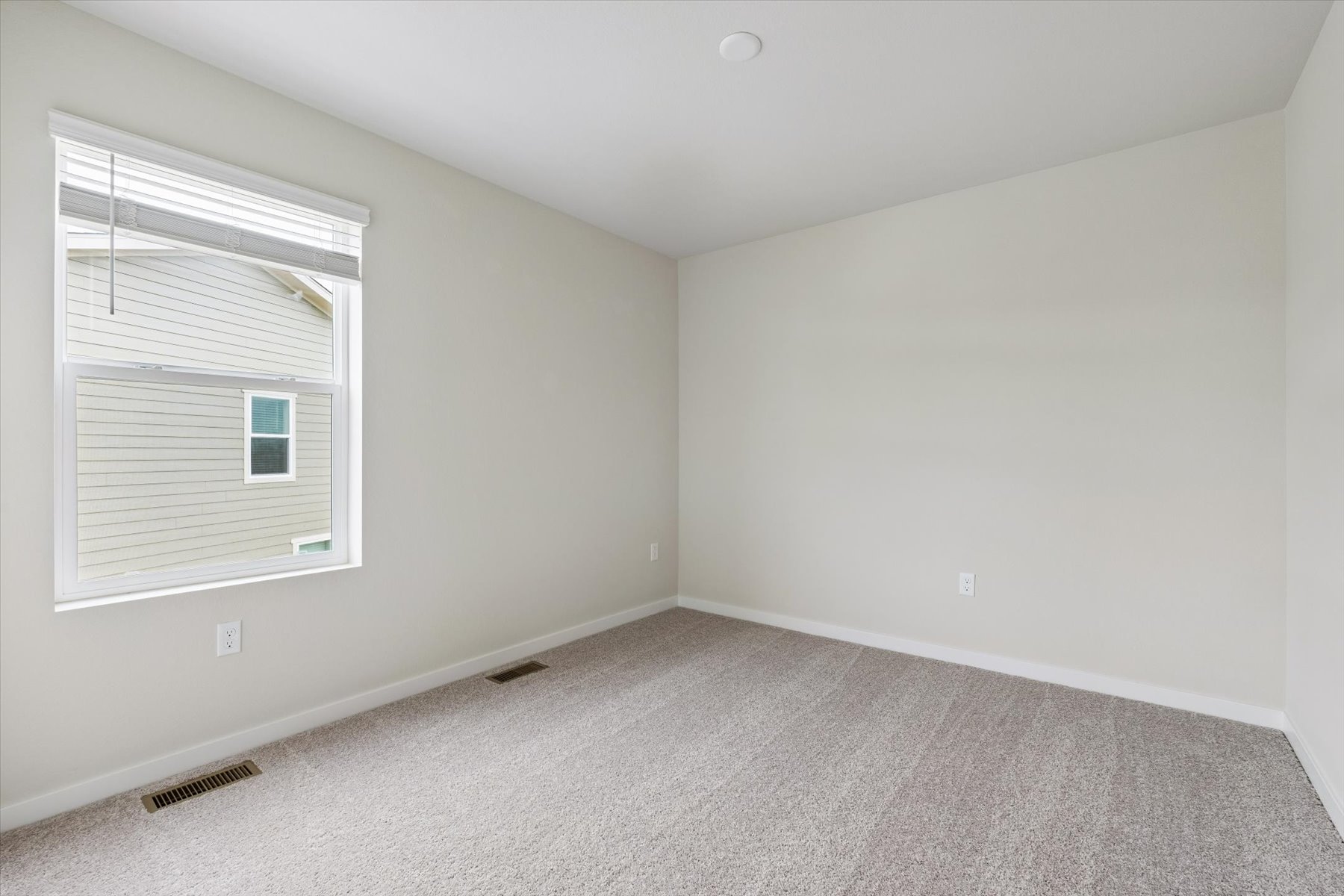 A room with a window and a carpet.