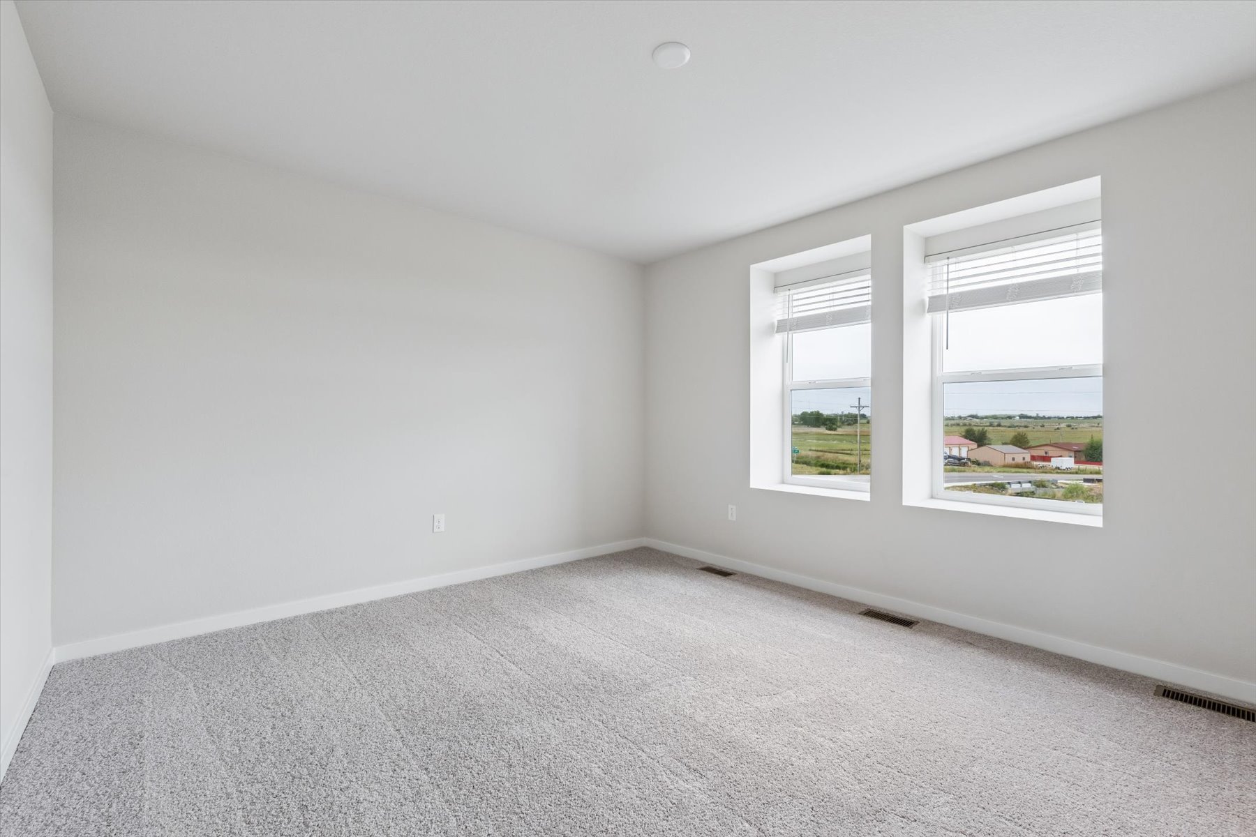 A room with a window and a white wall.