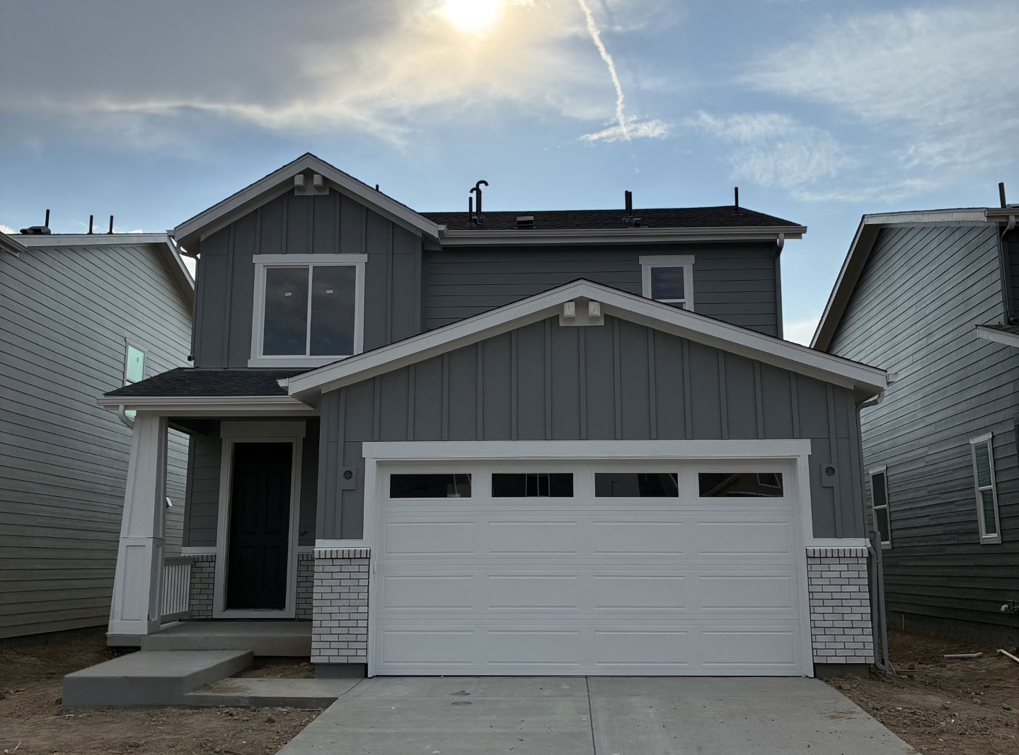 A grey house with garages.