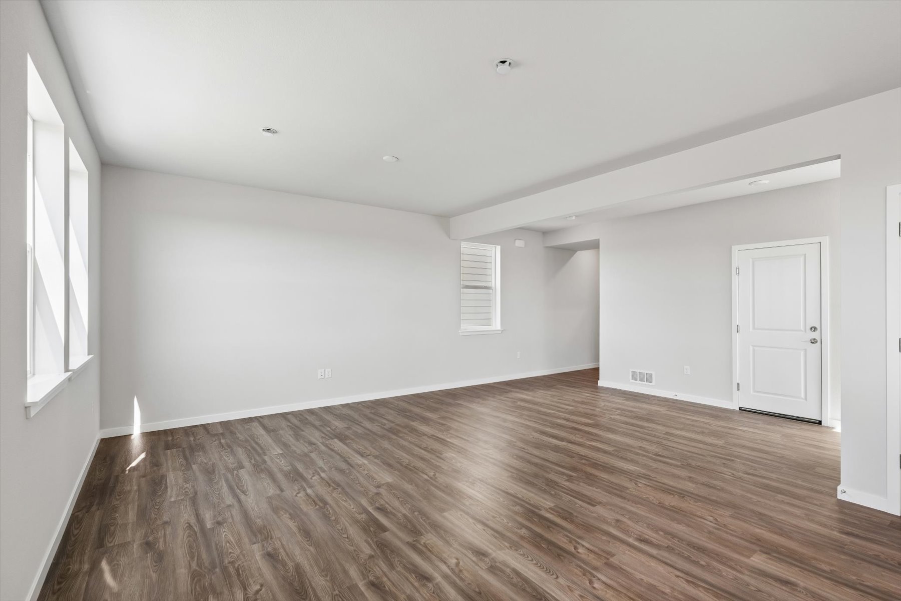 A room with a wood floor and white walls.