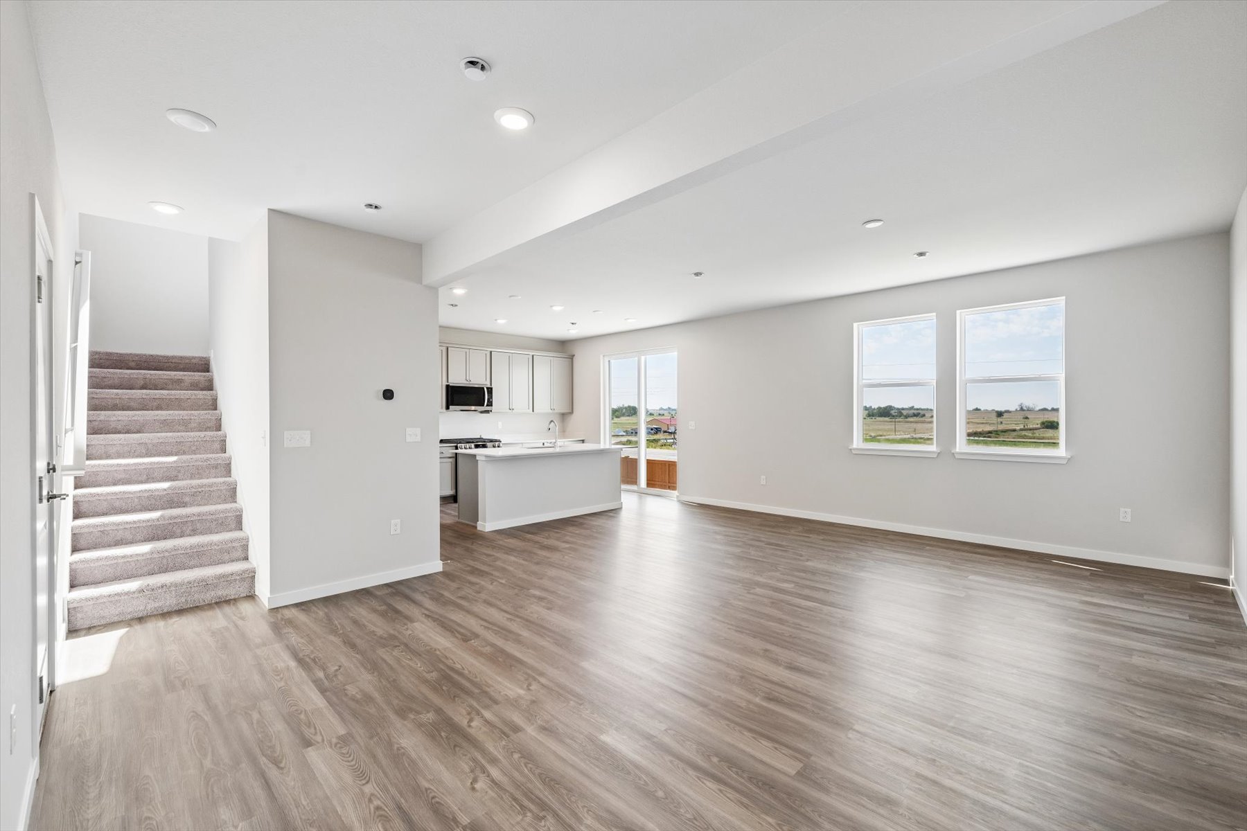 A large empty room with a wood floor and white walls.