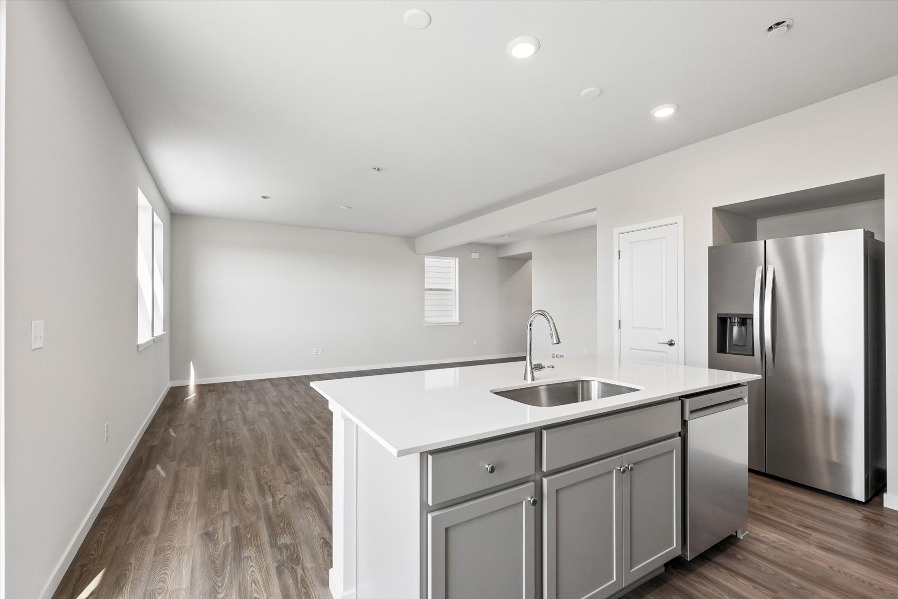 A kitchen with a sink and refrigerator.