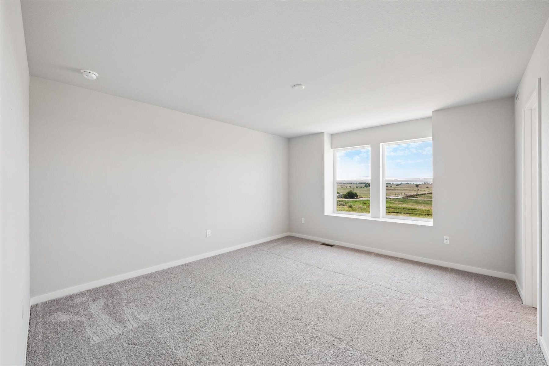 A room with a window and a carpet.
