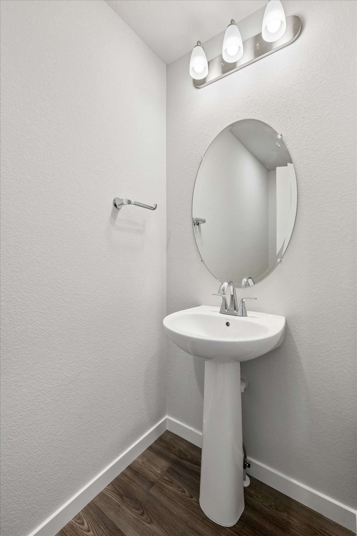 A bathroom with a round mirror.