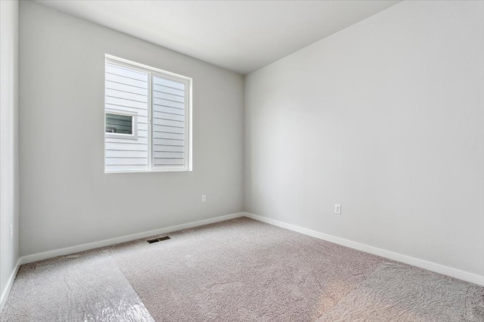 A room with a carpet and a window.