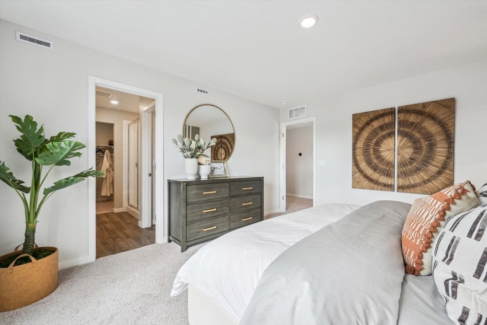 A bedroom with a bed and dresser.