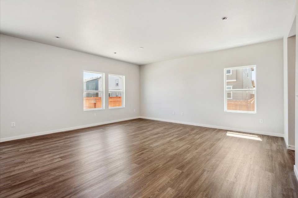 A room with a wood floor and windows.