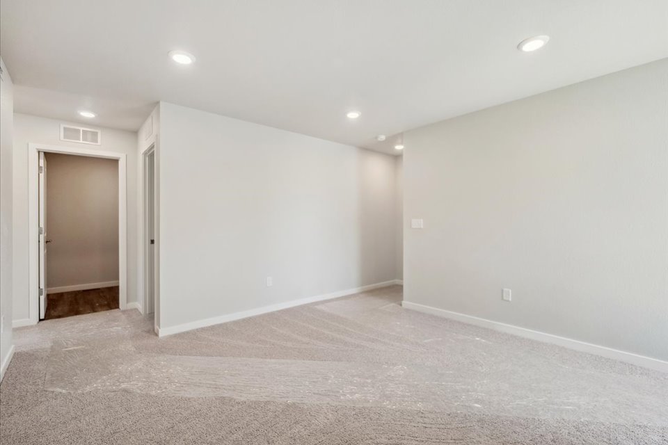 A room with a carpet and a door.