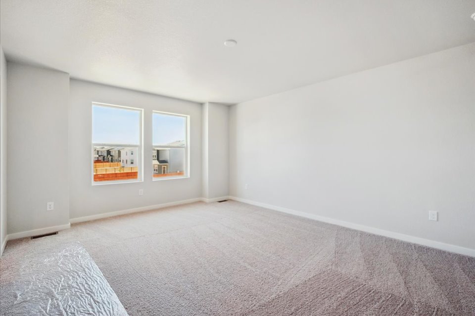 A room with a carpet and a window.