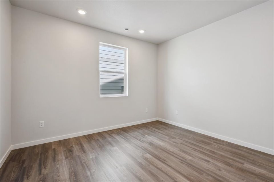 A room with a wood floor and a window.