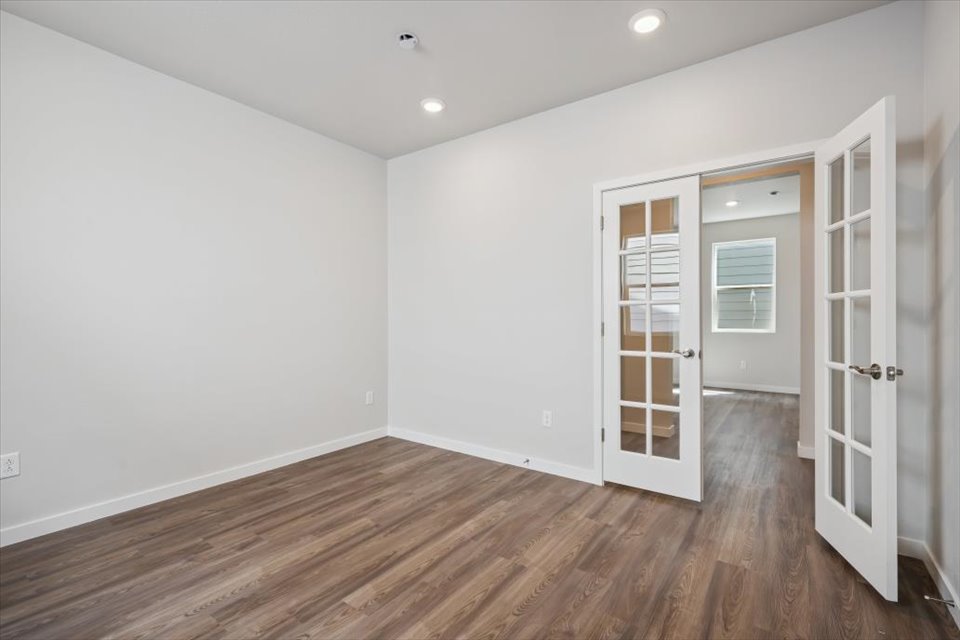 A room with white walls and wood floors.